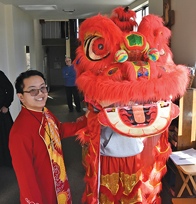 Vision 2026 Feister 3 Religious communities embrace diverse members Pictured here is Brother Thomas Nguyen, G.H.M. with a dragon dancer during a Glenmary Lunar New Year celebration.
